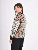 Cardigan de punto con diseño de animal print, cuello en V y cierre frontal con botones. Presenta puños y ruedo en tejido acanalado de color negro.