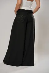 Pantalón negro súper campana de tiro medio en lino con bordados, con bolsillos delanteros y en la espalda. Cierre frontal con cremallera y botón.