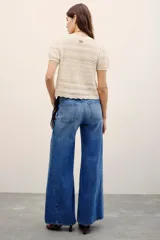 Jean de corte oxford y tiro medio, en color azul con lavado y detalles de costuras verticales en las piernas.