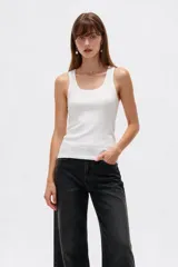 Musculosa blanca de canalé, con breteles anchos, cuello redondo y corte ajustado al cuerpo.