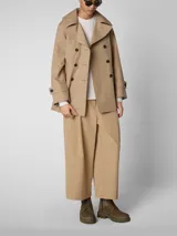 Campera trench corta color beige, con doble abotonadura frontal, cuello solapa y bolsillos laterales.