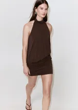 Vestido corto marrón con cuello halter y detalle drapeado en el torso, falda ajustada con fruncidos y diseño sin mangas.