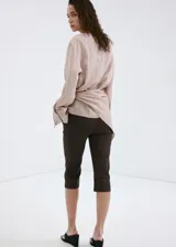 Pantalón capri de corte recto y color marrón, confeccionado en mezcla de lino y algodón con forro interior de algodón.