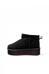 Pantubota corta de gamuza color negro, con plataforma gruesa y suela dentada. Cuenta con presilla en el talón para facilitar el calce.