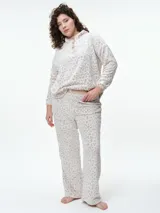 Buzo de dormir de tela fleece con estampado animal print en tonos grises y blancos. Presenta cuello alto con cierre de botones a presión y mangas largas.
