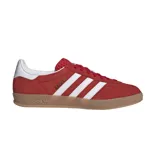 Championes Adidas modelo Gazelle Indoor, color rojo con las icónicas tres rayas laterales en blanco. Presentan una parte superior de gamuza, lengüeta texturizada y suela de goma color caramelo con el logo de Adidas grabado.