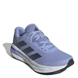 Championes de running Adidas modelo Galaxy 7, color lila con detalles en azul oscuro y suela blanca. Presentan parte superior textil transpirable, mediasuela con tecnología Cloudfoam para mayor amortiguación y cierre mediante cordones.