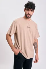Remera manga corta color beige, corte oversize, con estampa frontal "BOLD GRAPHIC" en marrón.