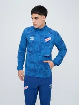 Campera deportiva Umbro del Club Nacional de Football, modelo Grok, en color azul con diseño estampado abstracto y cierre frontal completo. Cuenta con cuello alto, bolsillos laterales y elásticos en los puños.