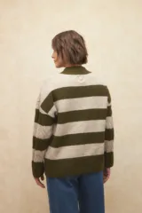 Polera de punto a rayas horizontales color beige y blanco, de manga larga y cuello alto.