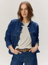 Campera de denim azul con cuello mao, cierre frontal con botones metálicos y presillas decorativas.