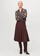 Camisa de poliéster con estampado animal print tipo cebra en tonos marrón, negro y beige, con cuello clásico y cierre frontal de botones.