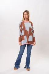 Buzo oversize de algodón con estampado geométrico en tonos marrones y celestes, con cuello y puños en color rosa.