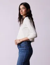 Cardigan tejido en hilado fino color blanco, marca Cable & Gauge. Abertura central con broche interno y terminación ondulada.