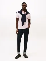 Chomba Tommy Hilfiger color rosado de corte regular, confeccionada en tejido jacquard de mezcla de algodón BCI y poliéster reciclado. Cuenta con cuello tipo chomba, billetera de dos botones, detalles distintivos de la marca y logo bordado en la manga.