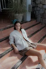 Chaqueta acolchada de algodón en color crudo, con diseño de matelassé, corte holgado, mangas largas y bolsillos frontales tipo parche.