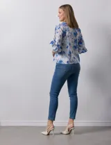 Blusa de gasa estampada con flores azules y violetas sobre fondo blanco, de manga 3/4 con volados.