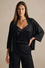 Kimono de corte abierto y holgado, con mangas tres cuartos y textura ligeramente brillante. Confeccionado en un tejido fluido y liviano, ideal para superponer en diversos looks.