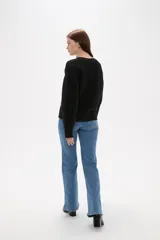 Sweater de punto color blanco, con cuello en V, manga larga y diseño holgado.