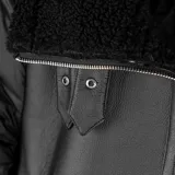 Campera negra de diseño híbrido que combina paneles de poliéster acolchado en las mangas con cuerpo de gamuza sintética. Presenta cuello, puños y ruedo con detalles de piel sintética tipo corderito, cierre frontal y dos bolsillos laterales con cierre.