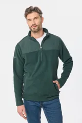 Buzo de micro polar con interior térmico, cuello alto y cierre frontal parcial. Presenta paneles de taslón al tono en el frente y cuello, con bolsillos laterales con cierre y detalle de logo en la manga.