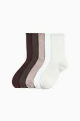 Pack de cinco pares de medias de caña media en punto acanalado, en colores marrón oscuro, marrón, beige, blanco y blanco hueso, con borde superior con volados.