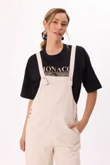 Enterito largo color beige, de corte holgado, con tirantes anchos regulables y bolsillos laterales.