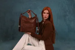 Mochila cartera de símil cuero color marrón, con compartimento principal amplio y bolsillos frontales con cierre. Cuenta con correas ajustables y asa superior para llevar al hombro o como mochila.