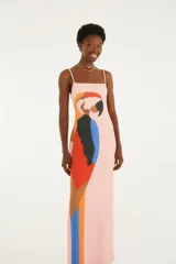 Vestido largo rosado de silueta recta y diseño sin mangas con finos breteles y escote cuadrado. Cuenta con un llamativo estampado frontal de un guacamayo en tonos rojo, azul, amarillo y negro.