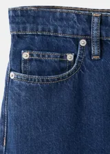 Jeans de denim azul oscuro con diseño de tiro medio y corte wide leg.