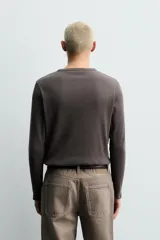 Camiseta de manga larga con cuello panadero y cierre frontal de botones. Confeccionada en tejido de algodón y cáñamo con textura acanalada.