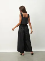 Mono negro con escote cuadrado, sin mangas, corte holgado y cintura elastizada.