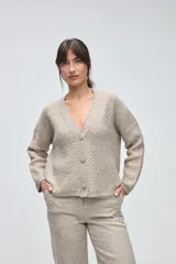 Cardigan de tejido de punto con textura, silueta boxy y cuello en V. Presenta cierre frontal con botones y detalles de terminación en contraste de color en los bordes.