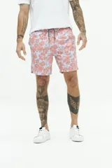 Short de baño con estampado floral en tonos rosados sobre fondo celeste. Cuenta con cintura elástica con cordón ajustable, bolsillos laterales y un bolsillo trasero.