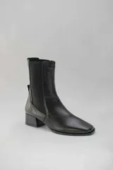 Botas de cuero color beige con elásticos laterales negros, taco cuadrado y punta cuadrada.