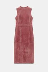 Vestido midi de piel color rosado, con cuello redondo y diseño sin mangas. Presenta costuras marcadas y cierre en la espalda con cremallera oculta.