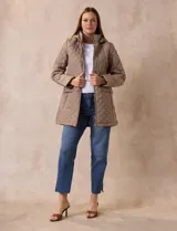 Campera capitoneada de corte largo con diseño acolchado en forma de rombos. Cuenta con cierre frontal completo, capucha desmontable, bolsillos delanteros con solapa y cierre, y forro interno a tono.