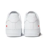 Zapatillas Nike Air Force 1 Low Supreme blancas de cuero, con logo de Nike en los laterales y logo de Supreme en el talón.