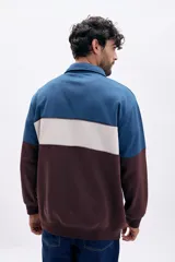 Buzo deportivo de hombre con medio cierre, cuello polo y diseño de bloques de color en azul, beige y marrón.