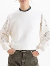 Buzo de calce regular con cuerpo de tela lisa y mangas largas de tejido calado con textura. Presenta escote redondo y puños ajustados.