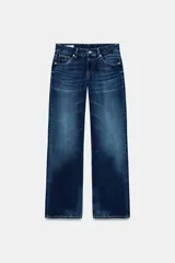 Jeans de tiro bajo y pernera ancha, de corte wide leg y largo completo. Presenta diseño de cinco bolsillos, cierre frontal con cremallera y botón metálico, y efecto lavado en tono azul oscuro.