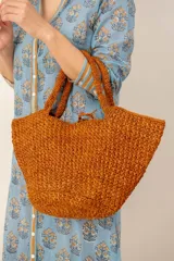 Bolso shopper de mano y hombro tejido a crochet en color naranja, de diseño amplio y asas cortas.