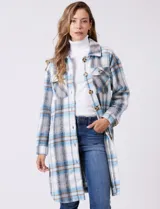 Sobrecamisa larga de tejido soft con estampado de cuadros en tonos celestes, beige y blanco. Presenta cuello con solapa, cierre frontal con botones, bolsillos aplicados en el pecho y mangas largas con puños abotonados.