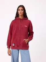 Canguro oversize color negro con efecto lavado, capucha y estampa gráfica en la espalda con tipografía desgastada y detalles en color turquesa.