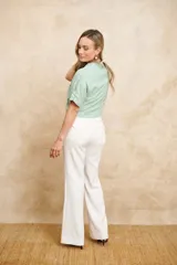 Chaqueta bomber corta color verde agua, con cierre frontal dorado, bolsillos grandes con cierre y mangas cortas ajustables con lazos.