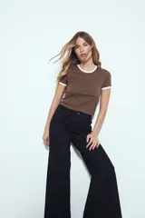 Pantalón de pierna amplia color beige, con silueta relajada y calce cómodo, confeccionado en denim con leve elasticidad. Presenta costuras a contraste.