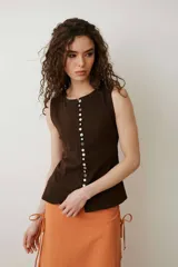Musculosa turquesa de algodón con escote redondo y cierre frontal decorado con una hilera de múltiples botones vintage variados.