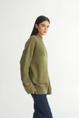 Buzo color verde oliva de punto con cuello alto, mangas largas y calce oversize.