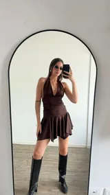 Vestido corto blanco con escote halter y falda con volados.