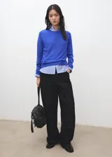 Jersey de punto fino de corte recto, color azul, con cuello redondo y manga larga.